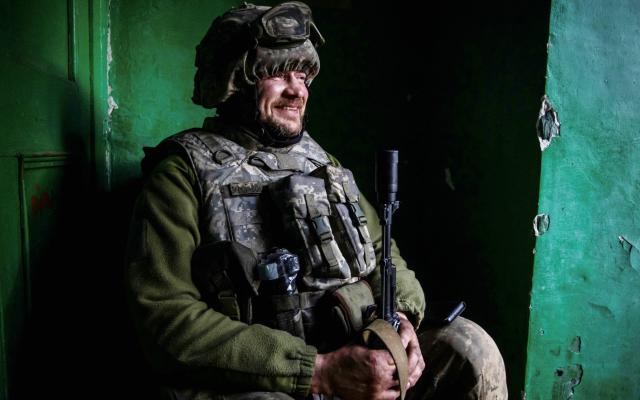 A Ukrainian service member smiles at a position outside of the frontline town of Bakhmut - Yevhenii Zavhorodnii/Reuters