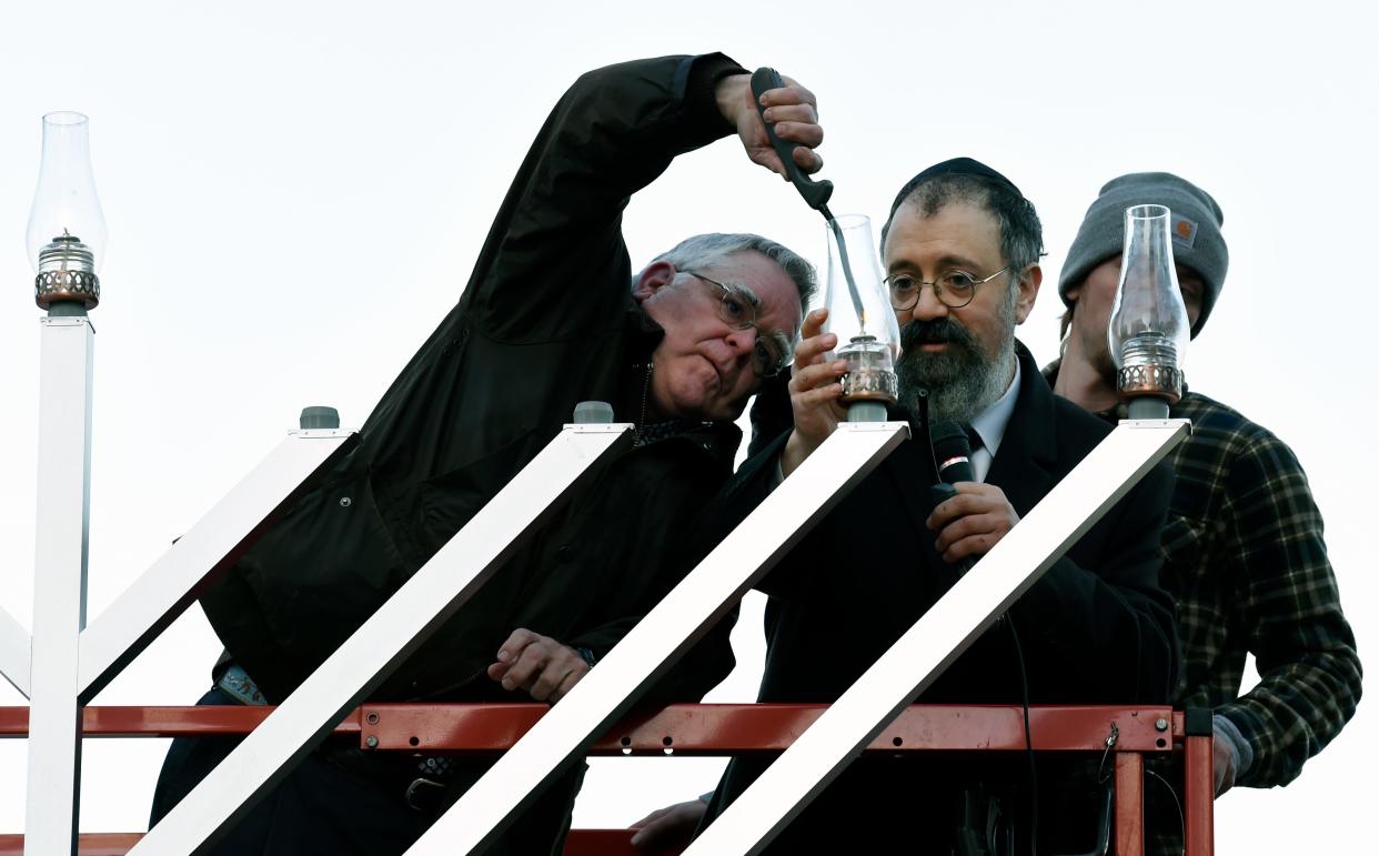 Nashville Mayor John Cooper and Rabbi Yitzchok Tiechtel light a menorah to celebrate the first day of Hanukkah at the downtown Public Square on Monday, November 29, 2021, in Nashville, Tenn. 