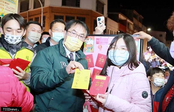 南市長黃偉哲快閃麻豆夜市送攤商抵用券賀年，祝福開春大吉，並邀民眾加碼抽福袋，藉此提振市場經濟。（記者李嘉祥攝）