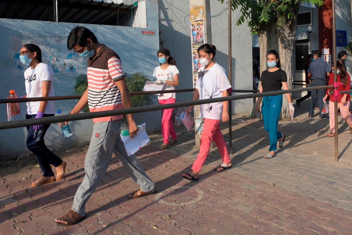 File photo: Students walk along a road as they come out from an exam centre after writing the Neet test on 13 September 2020 (AFP via Getty)