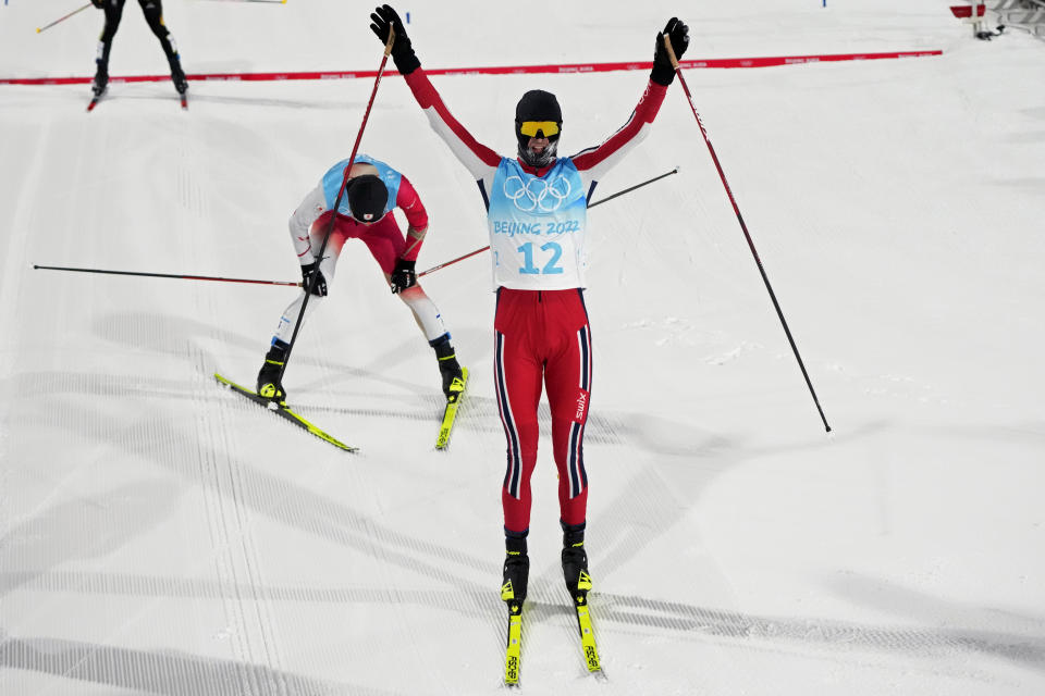 Norway's Joergen Graabak celebrates a gold medal finish ahead of bronze medal finisher Japan's Akito Watabe, left, during the cross-country skiing portion of the individual Gundersen large hill/10km competition at the 2022 Winter Olympics, Tuesday, Feb. 15, 2022, in Zhangjiakou, China. (AP Photo/Aaron Favila)