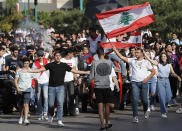 Student protesters wave their national flags and shout slogans, as they protest against the government in front of the education ministry in Beirut, Lebanon, Friday, Nov. 8, 2019. Lebanese protesters are rallying outside state institutions and ministries to keep up the pressure on officials to form a new government to deal with the country's economic crisis. (AP Photo/Hussein Malla)