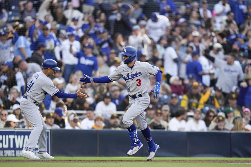 Los Angeles Dodgers' Chris Taylor (3) is greeted by third base coach Dino Ebel after hitting a two-run home run during the fourth inning of a baseball game against the San Diego Padres, Saturday, May 6, 2023, in San Diego. (AP Photo/Gregory Bull)