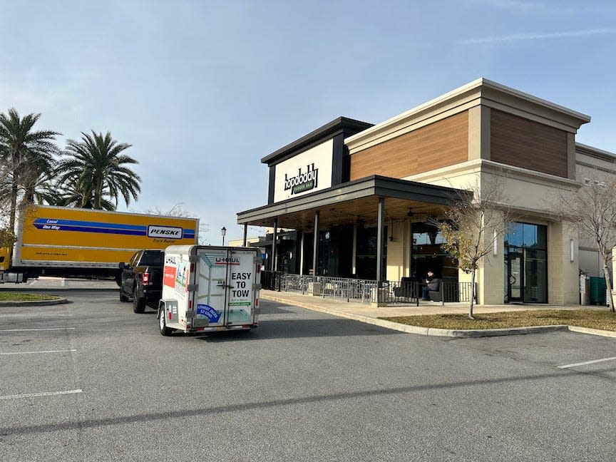 Moving vehicles are shown outside of the now closed Hopdoddy Burger Bar on Wednesday morning at 2917 SW 35th Drive in Gainesville.