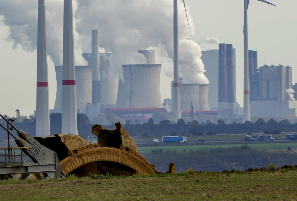 FILE - Steam comes out of the chimneys of the coal-fired power station Neurath near the RWE Garzweiler open-cast coal mine in Luetzerath, Germany, Monday, Oct.25, 2021. German energy giant RWE says it will phase out the burning of coal by 2030, saving 280 million metric tons of climate-changing greenhouse gas emissions. The decision announced Tuesday will accelerate the closure of some of Europe’s most polluting power plants and a vast lignite strip mine in the west of the country. (AP Photo/Michael Probst, File)