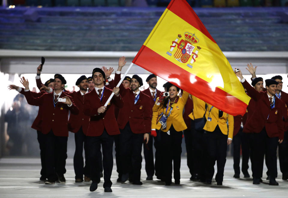 Javier Fernandez of Spain carries the national flag as he leads the team as they arrive during the opening ceremony of the 2014 Winter Olympics in Sochi, Russia, Friday, Feb. 7, 2014. (AP Photo/Mark Humphrey)