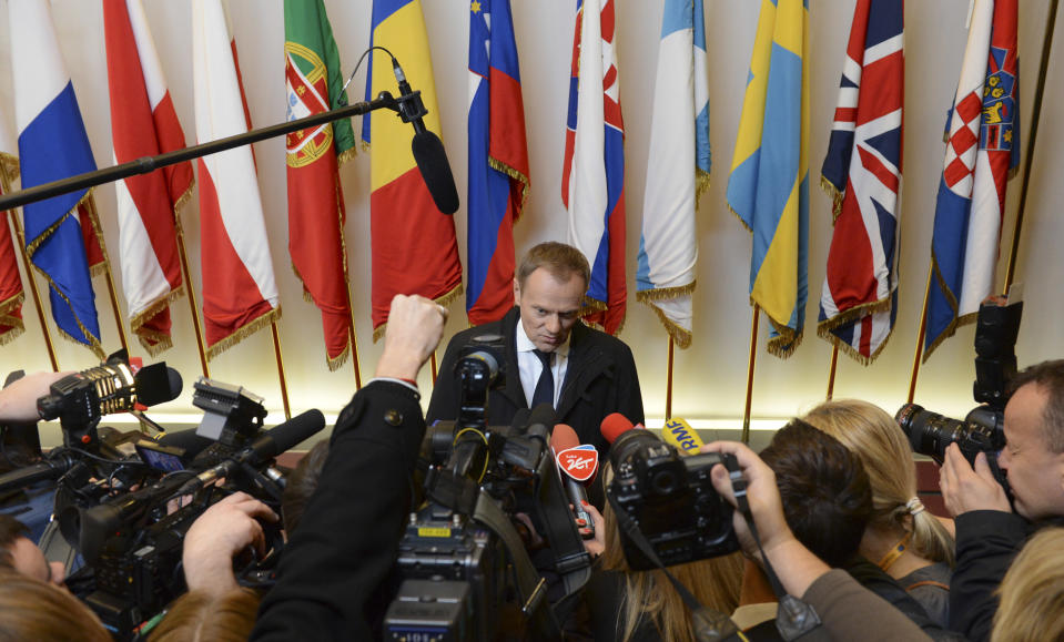 Poland's Prime Minister Donald Tusk, center, speaks with the media as he arrives for an EU summit in Brussels on Thursday, Nov. 22, 2012. EU leaders begin what is expected to be a marathon summit on the budget for the years 2014-2020. The meeting could last through Saturday and break up with no result and lots of finger-pointing. (AP Photo/Geert Vanden Wijngaert)