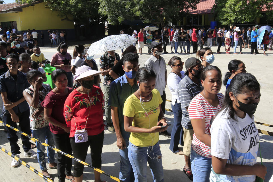 Residents line up to vote during the second round of the presidential election in Dili, East Timor, Tuesday, April 19, 2022. Voters in East Timor are choosing a president in a runoff Tuesday between former independence fighters who've blamed each other for years of political paralysis. (AP Photo/Lorenio do Rosario Pereira)