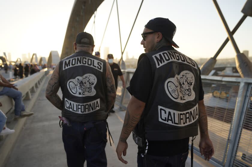 People wearing Mongols Motorcycle Club vests walk over the Sixth Street Bridge in Los Angeles on Saturday, July 9, 2022. (AP Photo/Damian Dovarganes)