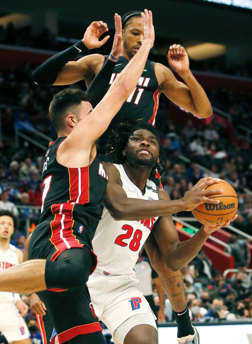 Pistons center Isaiah Stewart tries to shoot against Heat guard Max Strus, left, and forward KZ Okpala during the first half on Sunday, Dec. 19, 2021, at Little Caesars Arena.