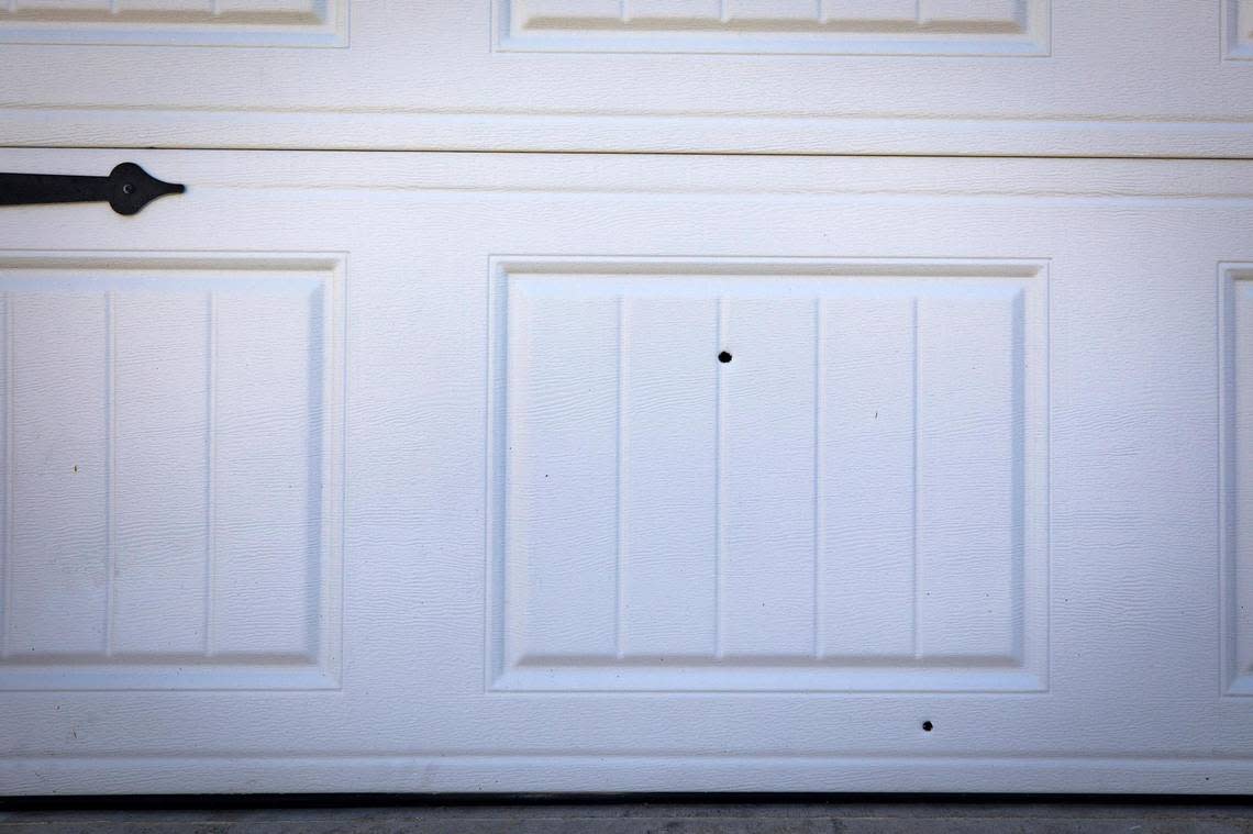 Bullet holes are visible in the garage door at a Fort Worth home where a 5-year-old and a 17-year-old were fatally shot on Sunday. A toddler was also hurt, but is expected to survive.