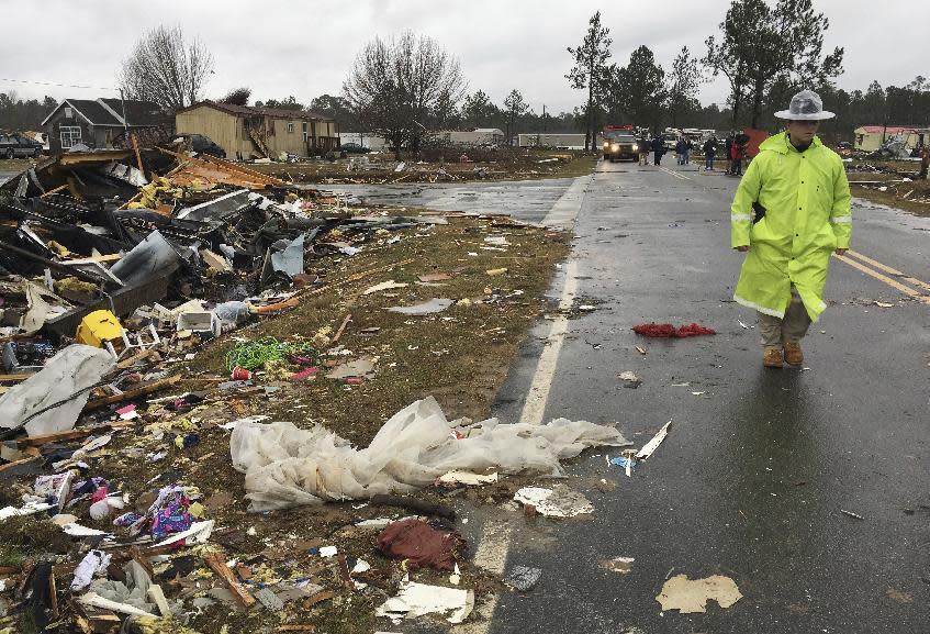 ADDS DATE - A Georgia state trooper walks past a mobile home destroyed by severe weather in Adel, Ga., Monday, Jan. 23, 2017. Gov. Nathan Deal declared a state of emergency in several counties, including Cook, that have suffered deaths, injuries and severe damage from weekend storms and expanded it Monday to include additional counties in southern Georgia. (AP Photo/Brendan Farrington)