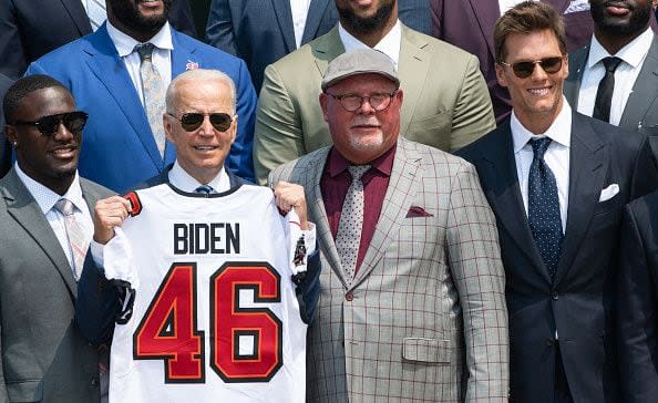 US President Joe Biden holds a jersey alongside Tampa Bay Buccaneers head coach Bruce Arians (2nd R) and quarterback Tom Brady (R) during a ceremony honoring the Tampa Bay Buccaneers NFL football team for their Super Bowl LV Championship on the South Lawn of the White House in Washington, DC, July 20, 2021. (Photo by SAUL LOEB / AFP) (Photo by SAUL LOEB/AFP via Getty Images)