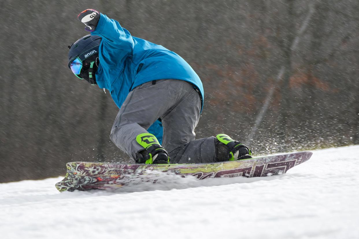 Ben Donaldson, 38, originally of Cincinnati, shreds down the black diamond Center Stage slope on his snowboard on Saturday, Dec. 30, 2023, at Perfect North Slopes in Lawrenceburg, Ind.