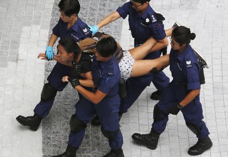 A protester is taken away by policewomen after storming into the government headquarters in Hong Kong September 27, 2014. REUTERS/Bobby Yip