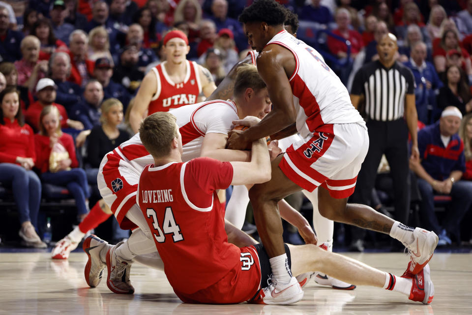 Utah center Lawson Lovering battles for control of a loose ball with Arizona guard KJ Lewis and center Motiejus Krivas (14) during the first half of an NCAA college basketball game Saturday, Jan. 6, 2024, in Tucson, Ariz. (AP Photo/Chris Coduto)