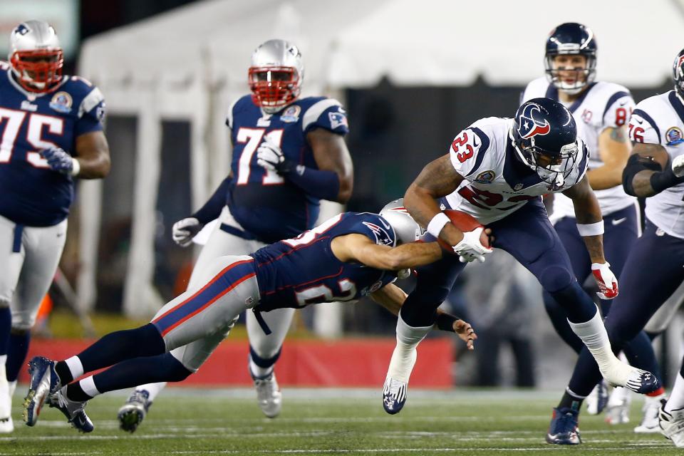 Running back Arian Foster #23 of the Houston Texans runs the ball as he is hit by strong safety Steve Gregory #28 of the New England Patriots in the first half at Gillette Stadium on December 10, 2012 in Foxboro, Massachusetts. (Photo by Jared Wickerham/Getty Images)