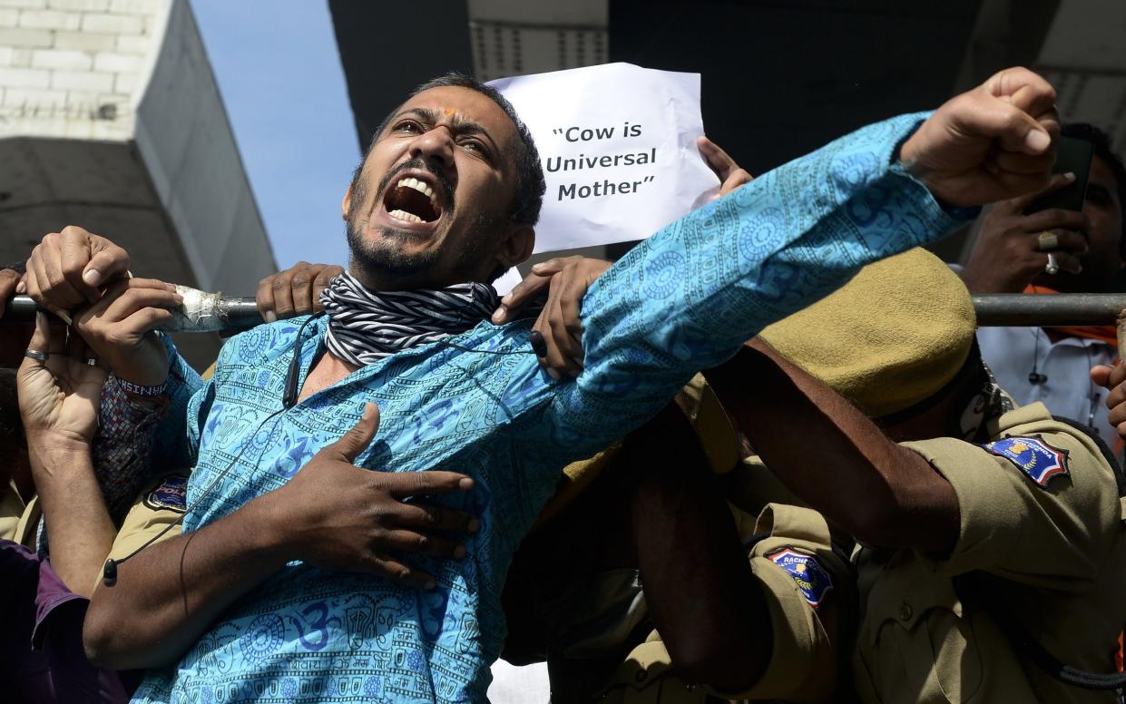 Police detain a member of the Hindu nationalist and right-wing federation of cattle protection Bhartiya Gau Raksha Dal shouting slogans for the protection of cows - Noah Seelam/AFP