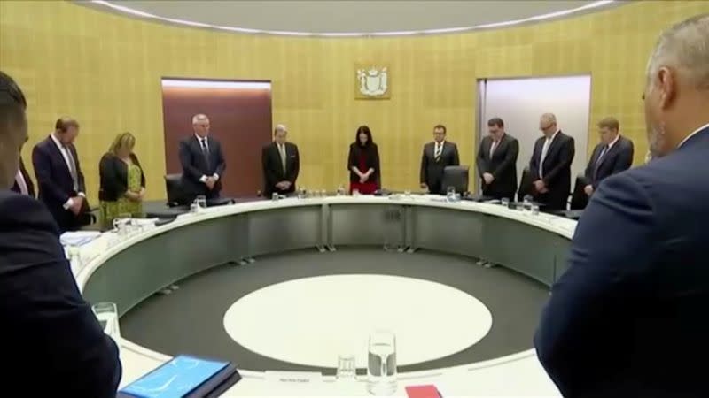 New Zealand's Prime Minister Ardern and fellow politicians observe a minute of silence to mark one week since the deadly eruption of White Island