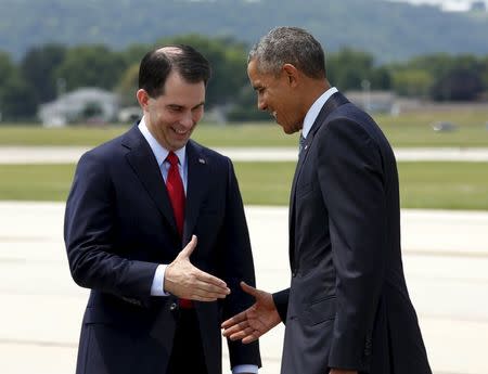 U.S. President Barack Obama is greeted by Wisconsin Governor Scott Walker upon his arrival in La Crosse, Wisconsin July 2, 2015. REUTERS/Kevin Lamarque