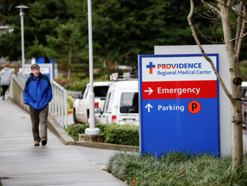 A man walks by the Providence Regional Medical Center campus after coronavirus victim treated in Everett