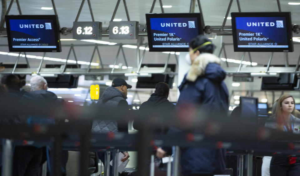 A man wears a protective mask as he waits to check into a flight to the United States in the main terminal of Brussels International Airport in Brussels, Friday, March 13, 2020. European Union interior ministers on Friday were trying to coordinate their response to the COVID-19 coronavirus as the number of cases spreads throughout the 27-nation bloc and countries take individual measures to slow the disease down. For most people, the new coronavirus causes only mild or moderate symptoms, such as fever and cough. For some, especially older adults and people with existing health problems, it can cause more severe illness, including pneumonia. (AP Photo/Virginia Mayo)