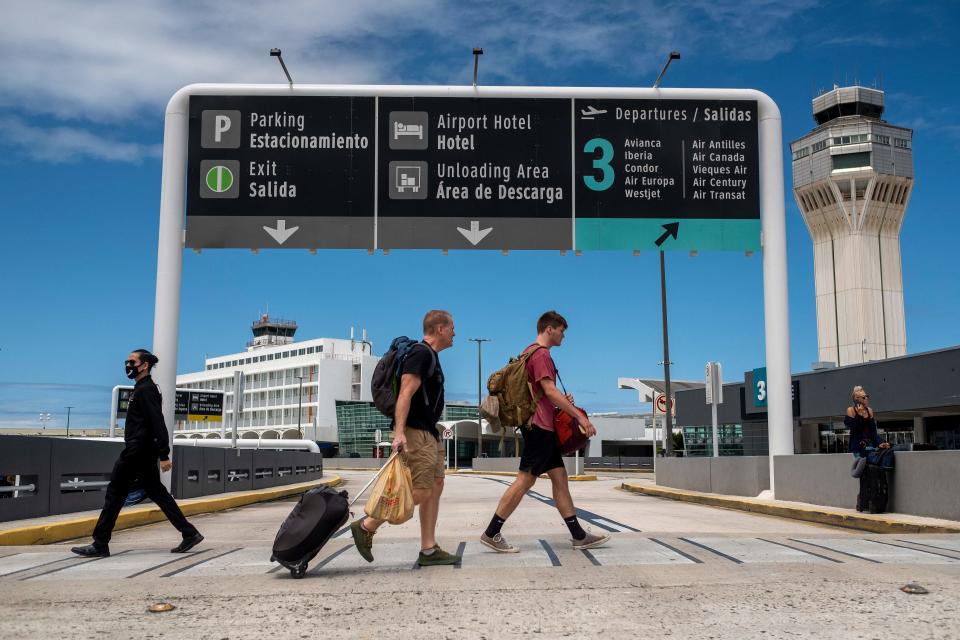 Travelers are seen outside the Luis Munoz Marin International Airport in San Juan, Puerto Rico on March 18, 2020.