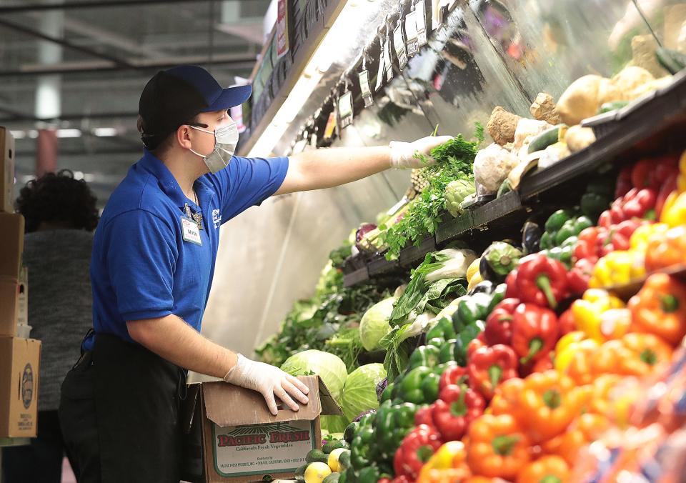 Devon Street, a produce associate at Acme Fresh Market in North Canton stocks the section with fresh produce.