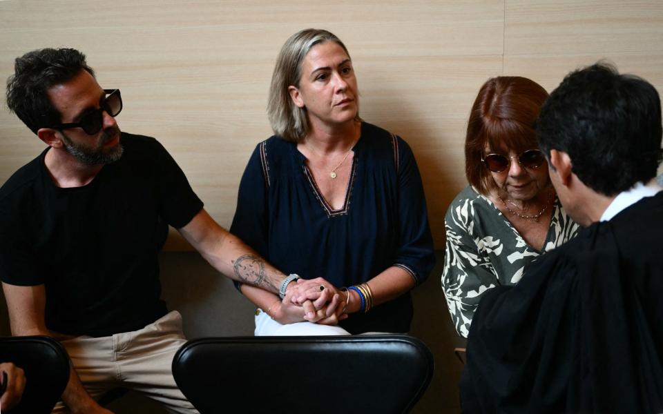 Caroline Darian flanked by her brother, left, and her mother Gisèle, right, in the courthouse during the trial