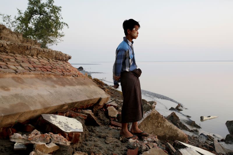 A student stands near the rubble of a school after it collapsed into the water in Ta Dar U village, Bago, Myanmar