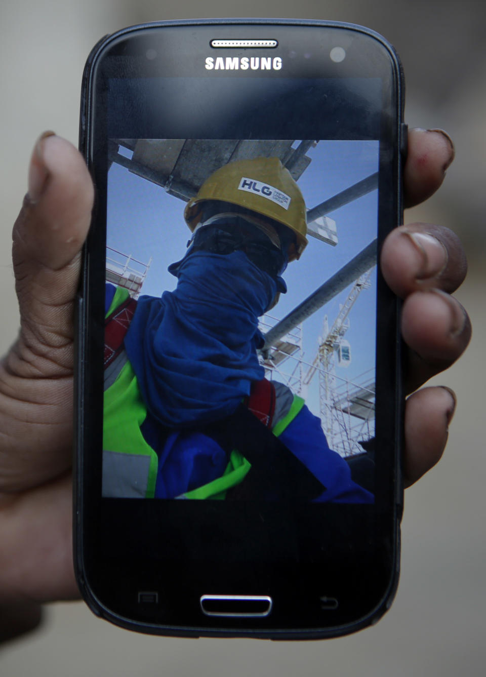 In this Wednesday, Nov. 30, 2016, Saro Kumari Mandal, 26, holds a mobile phone displaying a selfie her husband Balkisun Mandal Khatwe had taken in Qatar in his yellow work hardhat and protective sunglasses, at her village in Belhi, Saptari District of Nepal. Saro had chatted with Balkisun through Facebook Messenger just the evening before his death. This is what happened, according to his supervisor: "After work he went to dinner at 7 and bed at 10. In the morning we tried to wake him up but he didn't respond. We took the body to the hospital where they did an autopsy and said it was cardiac arrest." About 10 percent of Nepal's 28 million residents are working abroad. They send back more than $6 billion a year, amounting to about 30 percent of the country's annual revenues. Only Tajikistan and Kyrgyzstan are more dependent on foreign earnings. (AP Photo/Niranjan Shrestha)