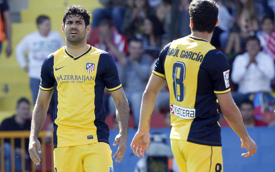 Atletico de Madrid's Diego Costa, left, and Raul Garcia, right, react during a Spanish La Liga soccer match against Levante at the Ciutat de Valencia stadium in Valencia, Spain, on Sunday, May 4, 2014. (AP Photo/Alberto Saiz)