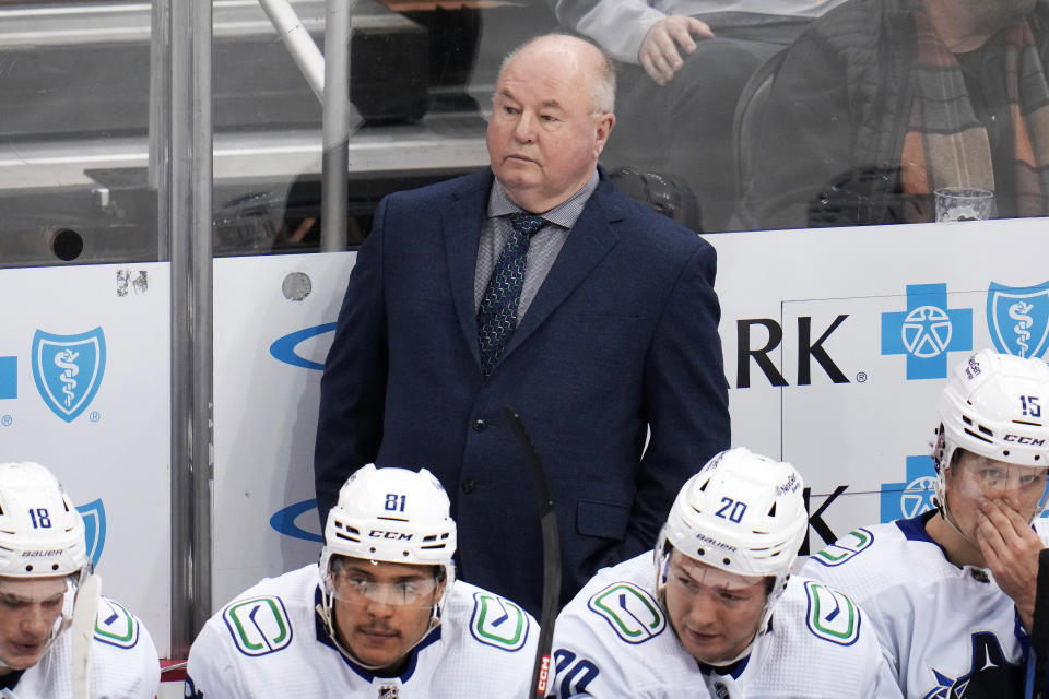 Vancouver Canucks coach Bruce Boudreau stands behind the bench during the first period of the team's NHL hockey game against the Pittsburgh Penguins in Pittsburgh, Tuesday, Jan. 10, 2023. The Penguins won 5-4. (AP Photo/Gene J. Puskar)