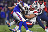 Buffalo Bills running back Devin Singletary, left, is tackled by New England Patriots defensive end Lawrence Guy, center, during the first half of an NFL football game in Orchard Park, N.Y., Monday, Dec. 6, 2021. (AP Photo/Adrian Kraus)