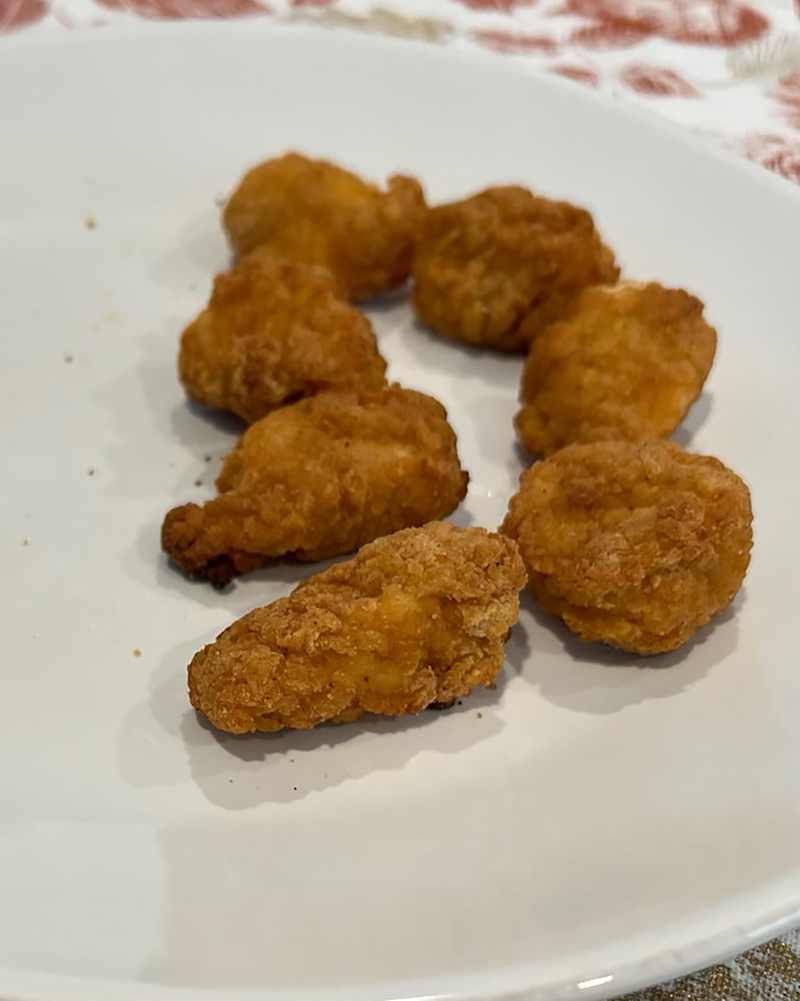 Breaded chicken breasts on plate.