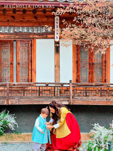 <p>Courtesy of Magnolia Journal</p> Joanna Gaines helping her youngest son Crew with his hanbok.