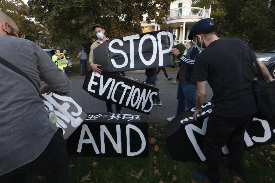 Housing activists erect a sign in front of Massachusetts Gov. Charlie Baker's house, Wednesday, Oct. 14, 2020, in Swampscott, Mass. The protesters were calling on the governor to support more robust protections against evictions and foreclosures during the ongoing coronavirus pandemic. (AP Photo/Michael Dwyer)