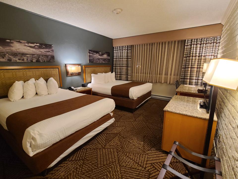 Hotel room with brown carpet and two queen beds 