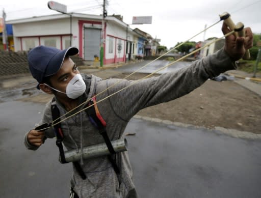 An anti-government demonstrator holding a homemade mortar uses a slingshot during clashes with riot police at a barricade in the town of Masaya, a flashpoint city of anti-government protests demanding President Ortega's ouster