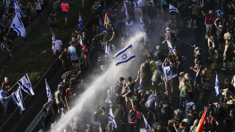 Israeli police use a water cannon to disperse demonstrators blocking a road during a protest in Jerusalem on Monday. - Mahmoud Illean/AP