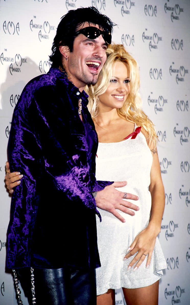 A pregnant Pamela Anderson and Tommy Lee pose on the red carpet. (Photo: Kevin Mazur/WireImage)