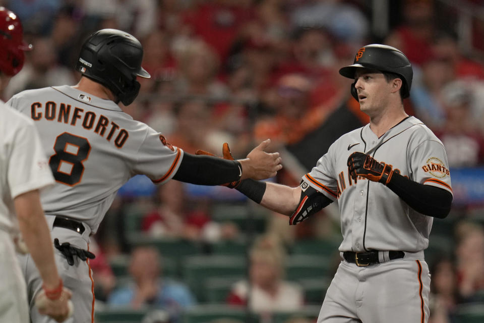 San Francisco Giants' Mike Yastrzemski, right, is congratulated by teammate Michael Conforto (8) after hitting a two-run home run during the sixth inning of a baseball game against the St. Louis Cardinals Tuesday, June 13, 2023, in St. Louis. (AP Photo/Jeff Roberson)