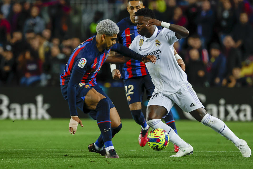 Real Madrid's Vinicius Junior, right, and Barcelona's Ronald Araujo fight for the ball during Spanish La Liga soccer match between Barcelona and Real Madrid at the Camp Nou stadium in Barcelona, Spain, Sunday, March 19, 2023. (AP Photo/Joan Monfort)