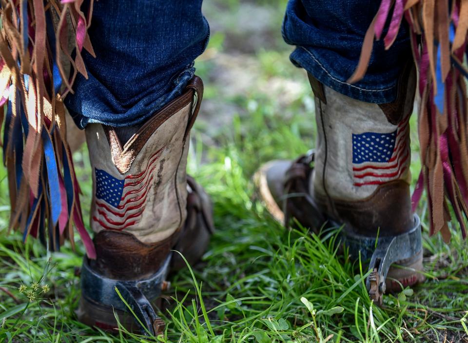 Getting ready to ride, Trip Burley wears his American flag cowboy boots and spurs at the Fellsmere Riding Club arena on Saturday, Sept. 10, 2022, in Fellsmere.