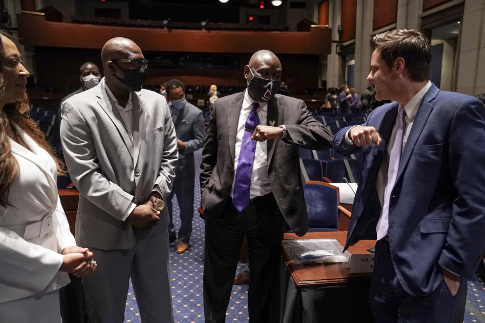 From left, Angela Underwood Jacobs, left, and Philonise Floyd, brother of George Floyd, watch as Ben Crump, civil rights attorney representing George Floyd's family, second from right, elbow bumps Rep. Matt Gaetz, R-Fla., right, during a break in a House Judiciary Committee hearing on proposed changes to police practices and accountability on Capitol Hill, Wednesday, June 10, 2020, in Washington. (Greg Nash/Pool via AP)