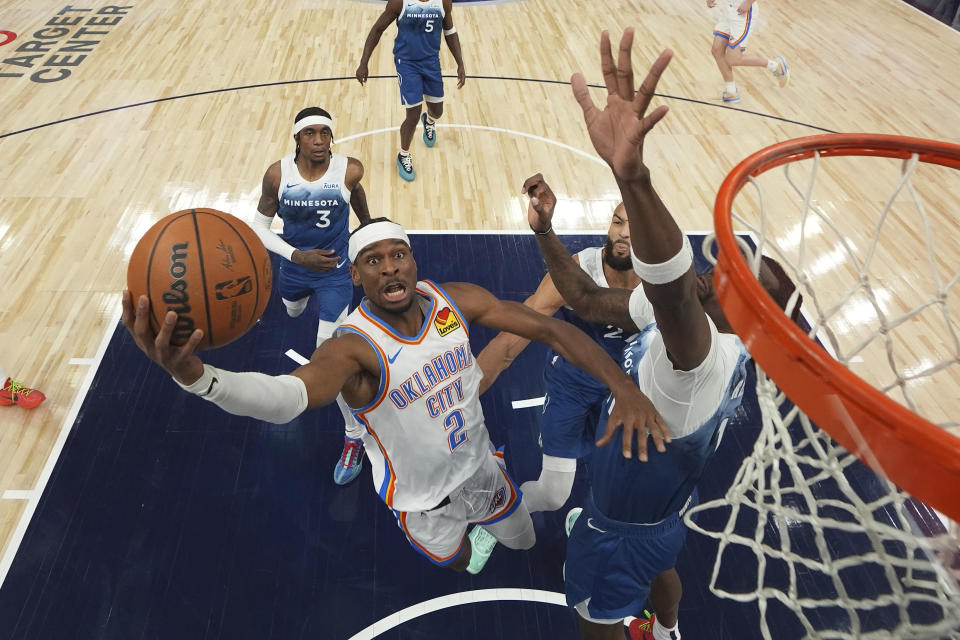 Oklahoma City Thunder guard Shai Gilgeous-Alexander (2) goes up to shoot as Minnesota Timberwolves center Naz Reid, right, defends during the first half of an NBA basketball game, Saturday, Jan. 20, 2024, in Minneapolis. (AP Photo/Abbie Parr)