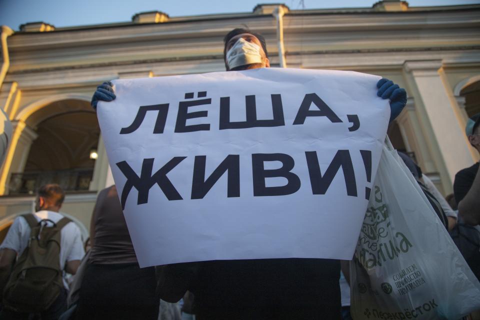 FILE - In this Aug. 20, 2020, file photo, a protester holds a poster reading "Lyosha, you must live!" in support of Russian opposition leader and corruption fighter Alexei Navalny in the center of St. Petersburg, Russia. Navalny is in a coma in a Berlin hospital after suffering what German authorities say was a poisoning with a chemical nerve agent while traveling in Siberia on Aug. 20. (AP Photo/Ivan Petrov, File)