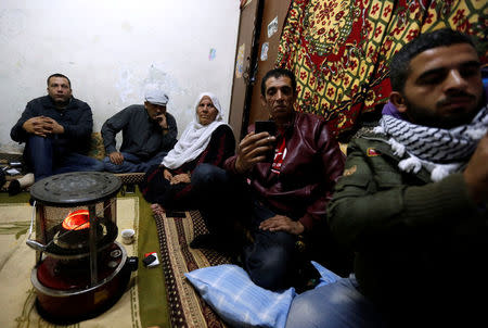 A Palestinian refugee family watches a televised broadcast of U.S. President Donald Trump delivering an address where he is expected to announce that the United States recognises Jerusalem as the capital of Israel, at Al-Baqaa Palestinian refugee camp, near Amman, Jordan December 6, 2017. REUTERS/Muhammad Hamed