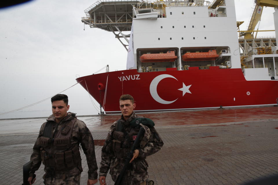 Turkish police officers patrol the dock, backdropped by the drillship 'Yavuz' scheduled to be dispatched to the Mediterranean, at the port of Dilovasi, outside Istanbul, Thursday, June 20, 2019. Turkish officials say the drillship Yavuz will be dispatched to an area off Cyprus to drill for gas. The Cyprus government says Turkey’s actions contravene international law and violate Cypriot sovereign rights. (AP Photo/Lefteris Pitarakis)