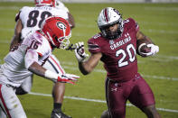 South Carolina running back Kevin Harris (20) carries the ball next to Georgia defensive back Lewis Cine (16) during the first half of an NCAA college football game Saturday, Nov. 28, 2020, in Columbia, S.C. (AP Photo/Sean Rayford)